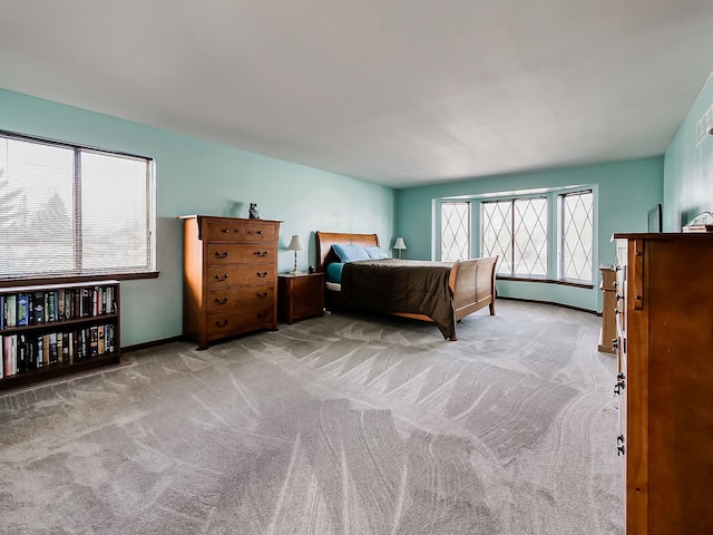 bedroom featuring light carpet and baseboards