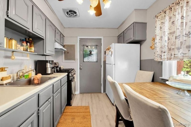 11235 Lozier Ave, Warren, MI 48089 - kitchen featuring visible vents, black gas range oven, gray cabinetry, freestanding refrigerator, and a sink