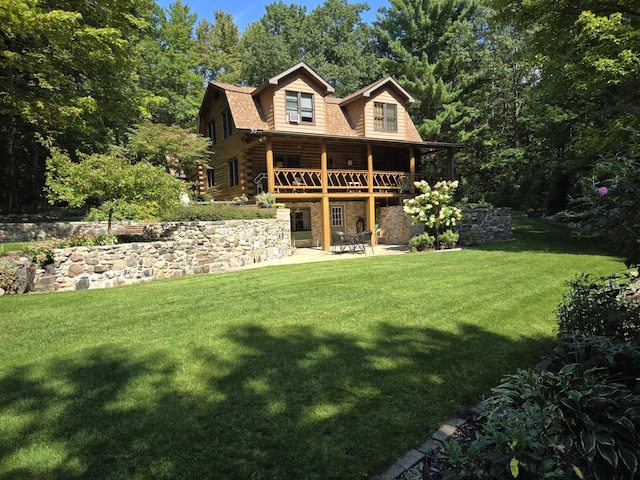 view of front of property featuring a patio, a gambrel roof, a front yard, a deck, and stone siding