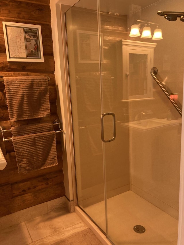 bathroom featuring rustic walls, a shower stall, and tile patterned flooring