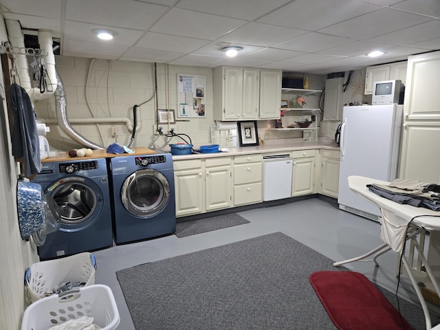 washroom featuring washing machine and dryer and concrete block wall