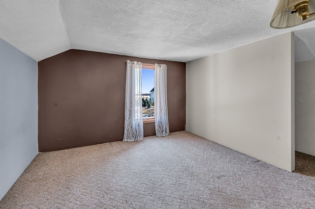 additional living space with lofted ceiling, a textured ceiling, and light colored carpet