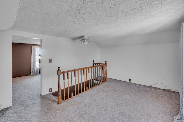 bonus room featuring a textured ceiling, carpet flooring, and a ceiling fan