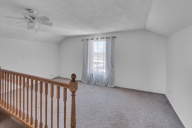 bonus room featuring lofted ceiling, a textured ceiling, a ceiling fan, and carpet flooring