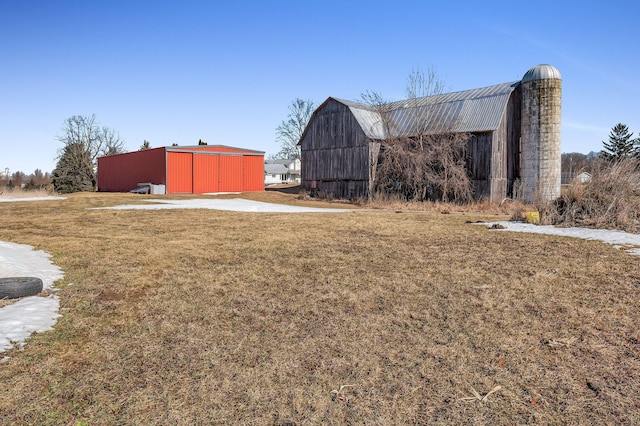 view of yard with a barn, a detached garage, and an outbuilding