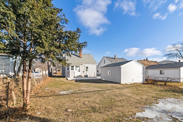 back of house featuring a yard, a patio, and fence