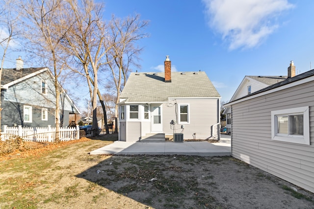 rear view of house featuring entry steps, a patio, a chimney, and fence