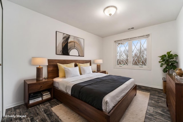 bedroom with dark wood-style flooring, visible vents, and baseboards