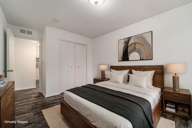 bedroom featuring dark wood-style floors, a closet, visible vents, and baseboards