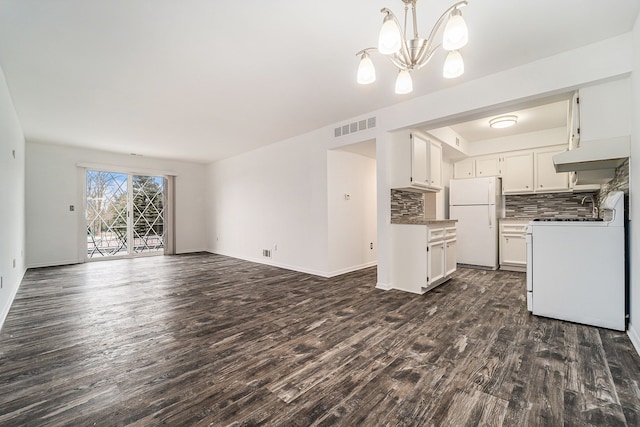 kitchen featuring open floor plan, white appliances, visible vents, and tasteful backsplash