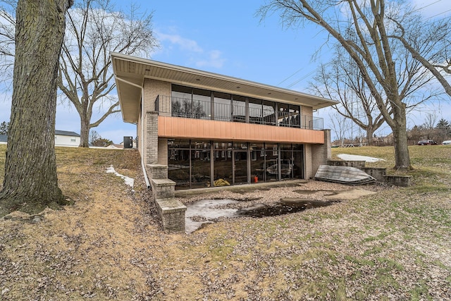 back of property featuring brick siding