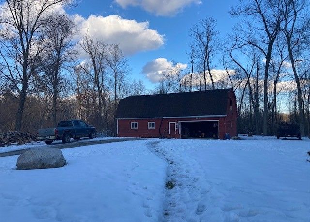 view of front of house with a barn, a gambrel roof, and an outbuilding