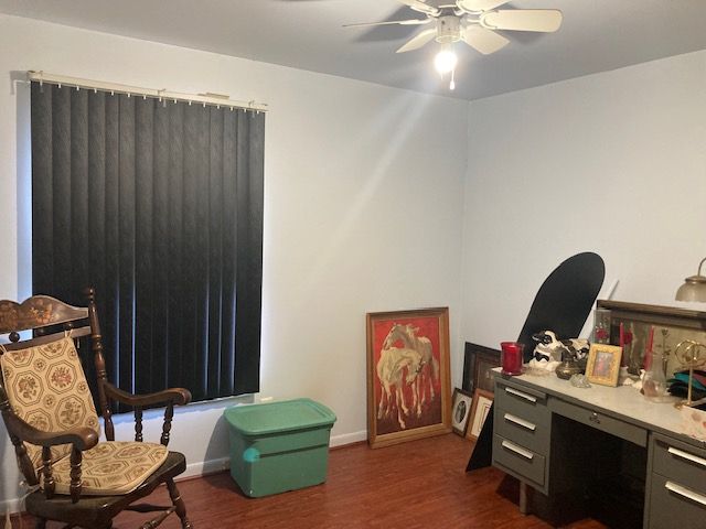 interior space featuring ceiling fan, baseboards, and dark wood-style flooring