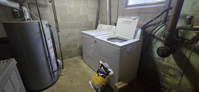 washroom featuring concrete block wall, laundry area, water heater, and washing machine and clothes dryer