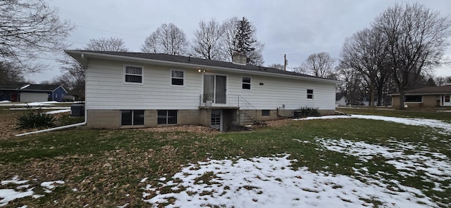 snow covered house with a chimney, central AC, and a yard