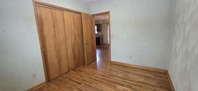 interior space featuring light wood-type flooring and baseboards