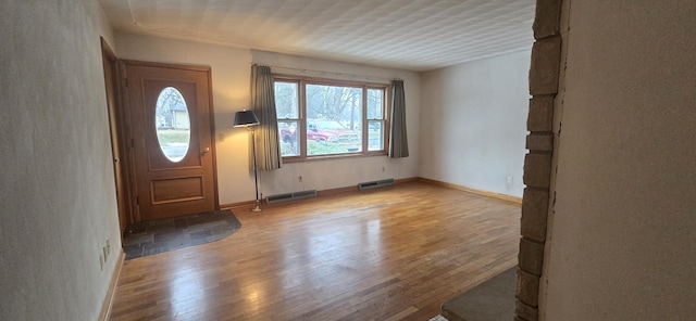 entrance foyer with light wood-style floors, visible vents, and baseboards