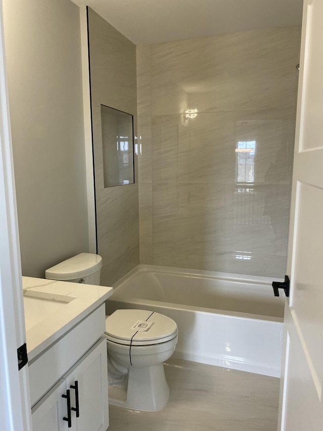 bathroom featuring toilet, washtub / shower combination, and vanity