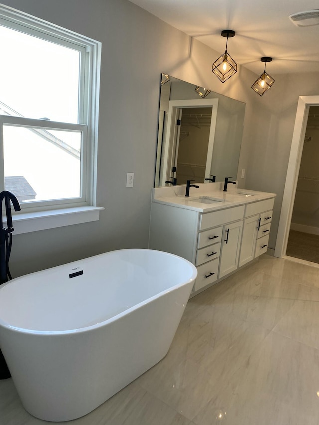 full bathroom featuring a freestanding tub, visible vents, a sink, and double vanity