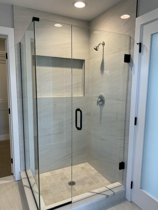 bathroom featuring a stall shower and a spacious closet