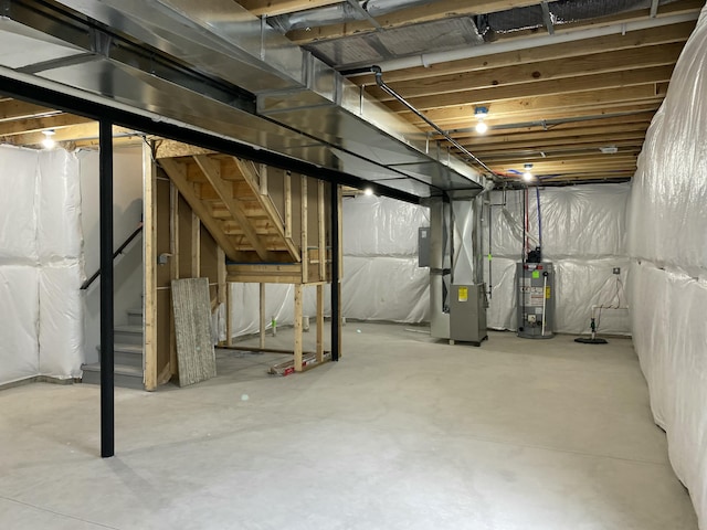 unfinished below grade area featuring stairs, gas water heater, and heating unit