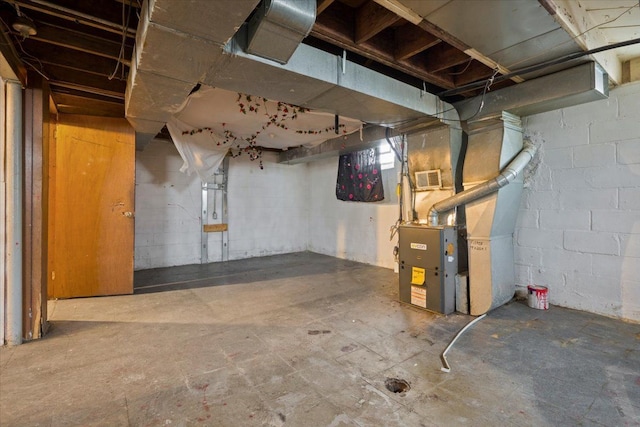 unfinished basement featuring heating unit and visible vents