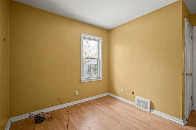 unfurnished room with light wood-type flooring, visible vents, and baseboards