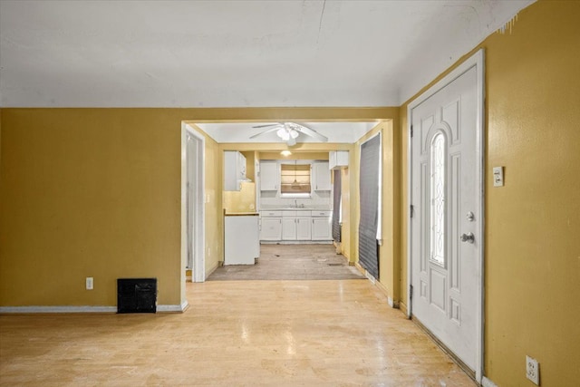 foyer with a ceiling fan, light wood-type flooring, and baseboards