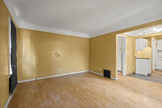 unfurnished room with light wood-type flooring and baseboards