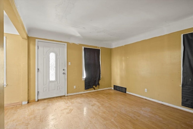 foyer with wood finished floors, visible vents, and baseboards