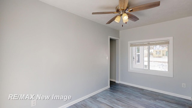 empty room featuring dark wood-type flooring, ceiling fan, and baseboards