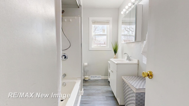 bathroom with shower / bath combination, baseboards, visible vents, wood finished floors, and vanity