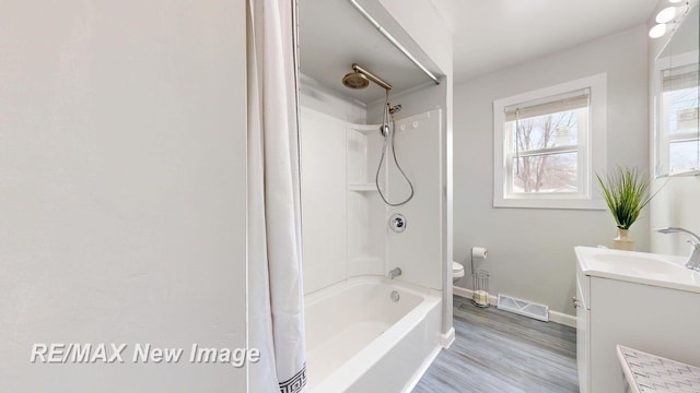 bathroom featuring visible vents, baseboards, toilet, shower / bathtub combination with curtain, and vanity