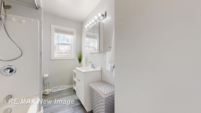 full bathroom featuring visible vents, vanity, baseboards, and wood finished floors