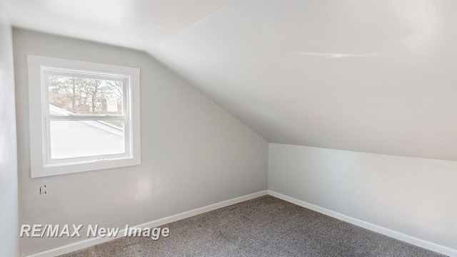 bonus room featuring vaulted ceiling, carpet, and baseboards