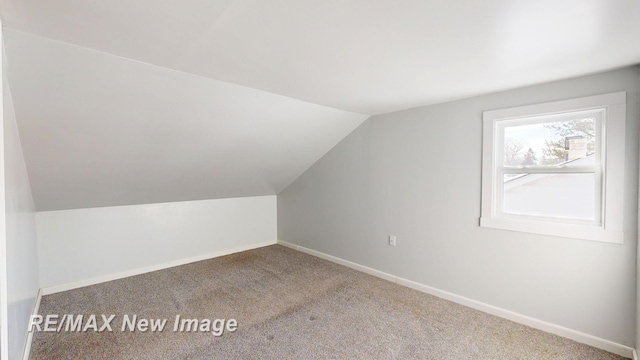 additional living space with vaulted ceiling, carpet, and baseboards