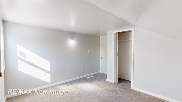 unfurnished bedroom with a closet, carpet flooring, and baseboards