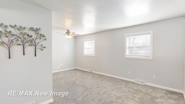 spare room featuring visible vents, light carpet, and baseboards