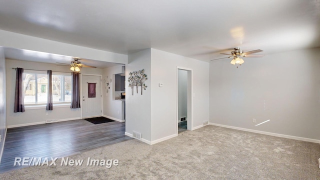 carpeted empty room with baseboards, visible vents, and ceiling fan