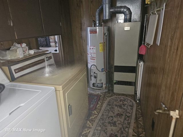 laundry room featuring gas water heater, washing machine and clothes dryer, and cabinet space