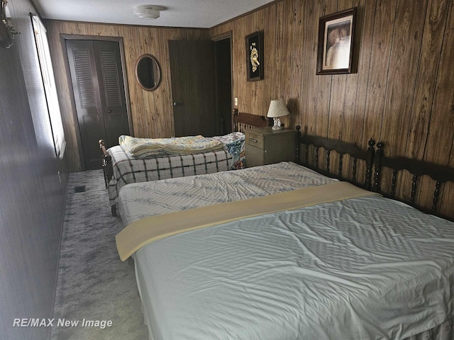 bedroom with wood walls and a closet