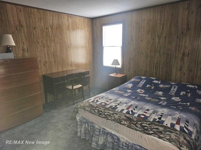 bedroom featuring a textured ceiling, carpet floors, and wooden walls