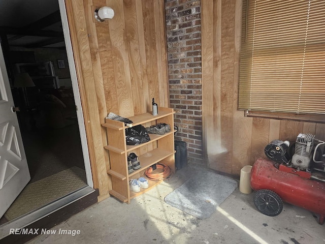 interior space featuring unfinished concrete flooring and wooden walls