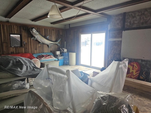 miscellaneous room featuring wooden walls and beamed ceiling