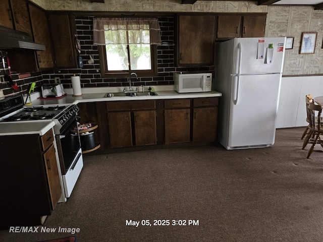 5243 Martin Rd, Beaverton, MI 48612 - kitchen with white appliances, under cabinet range hood, light countertops, dark brown cabinets, and dark carpet