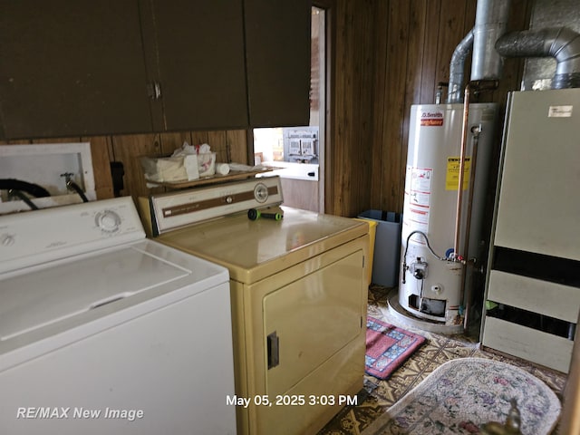 5243 Martin Rd, Beaverton, MI 48612 - laundry room with washing machine and dryer, gas water heater, wood walls, and cabinet space