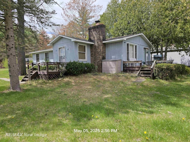 5243 Martin Rd, Beaverton, MI 48612 - rear view of house featuring a deck, a chimney, and a yard
