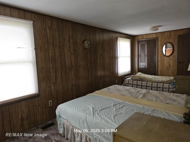 5243 Martin Rd, Beaverton, MI 48612 - carpeted bedroom with wood walls and a textured ceiling