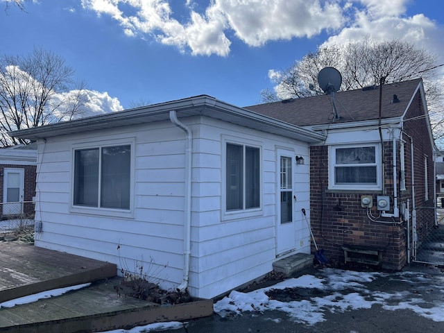 view of front of property with entry steps, a deck, and brick siding