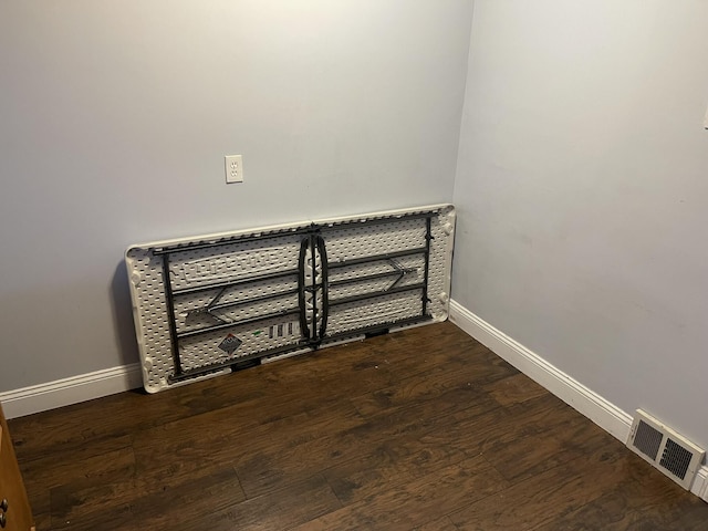 room details featuring wood finished floors, visible vents, and baseboards